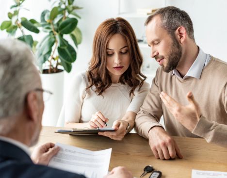 A married couple in Defiance, OH reviewing a Car Insurance policy with an agent