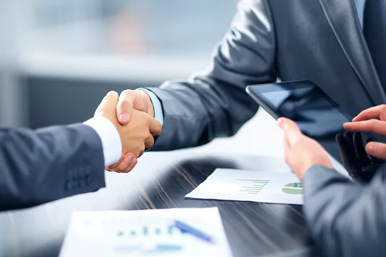 Business owners who use commercial surety bonds shaking hands in Archbold